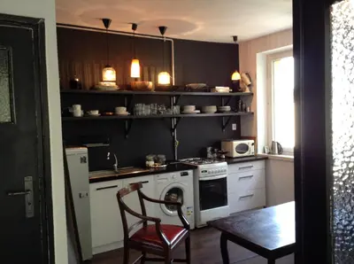 a kitchen with a stove and a table with a chair at Absolutely Apartment in Kraków