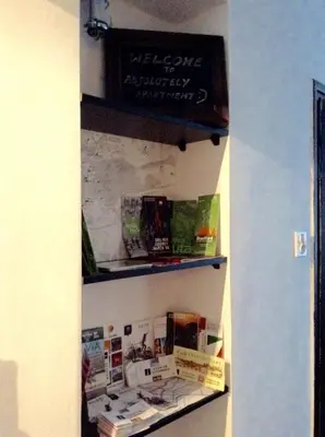 a book shelf with books on a wall at Absolutely Apartment in Kraków