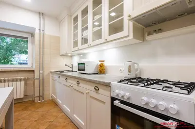 a kitchen with white cabinets and a stove top oven at Apartment Nearto Old Town Daszyńskiego street in Kraków