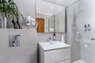 a white bathroom with a sink and a shower at Beautiful Cracow Apartments by Cozyplace in Kraków