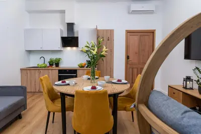 a kitchen and dining room with a table and chairs at Beautiful Cracow Apartments by Cozyplace in Kraków