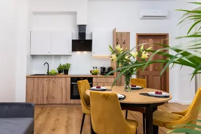 a kitchen and dining room with a wooden table and chairs at Beautiful Cracow Apartments by Cozyplace in Kraków