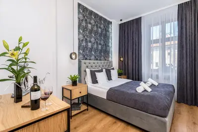 a bedroom with a bed and a table with wine glasses at Beautiful Cracow Apartments by Cozyplace in Kraków