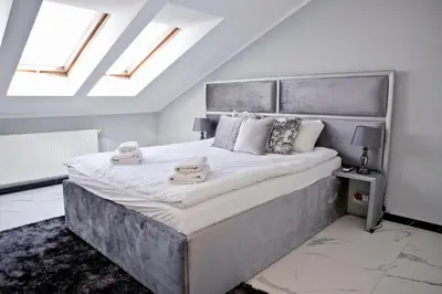 a bedroom with a large bed with two towels on it at Elegant City Center Apartment Pawlikowskiego 8 in Kraków