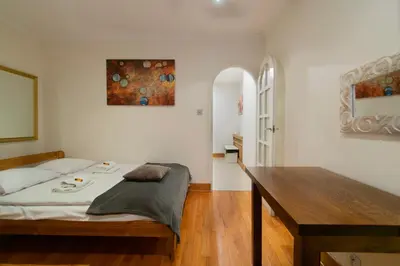 a bedroom with a bed and a wooden table at Stylish 2 bedroom apartment Morsztynowska street in Kraków