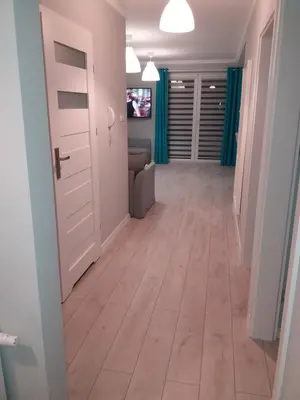 a hallway with a door and a couch at Apartament FAMILY- klimatyzacja in Oświęcim