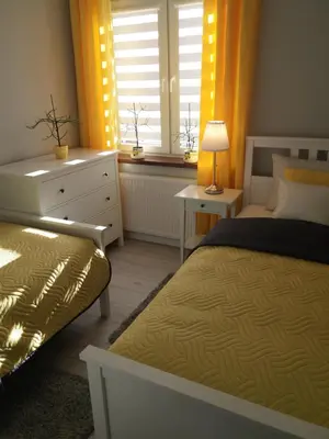 a bedroom with a bed and a dresser and a window at Apartament FAMILY- klimatyzacja in Oświęcim