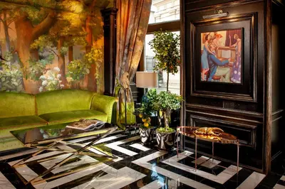 a living room with a green couch and a painting at Balthazar Design Hotel in Kraków