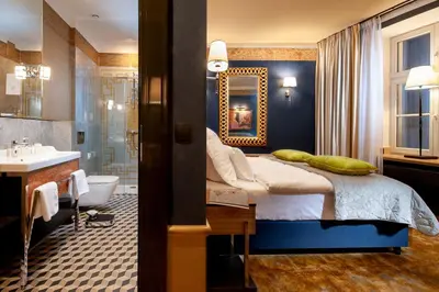 a bathroom with a bed and a tub and a sink at Balthazar Design Hotel in Kraków