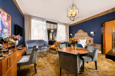a living room with a bed and a table and chairs at Balthazar Design Hotel in Kraków