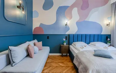 two beds in a room with blue walls at Central Apartments Warszawska Street in Kraków