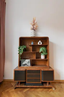 a wooden book shelf with two plants on it at Central Apartments Warszawska Street in Kraków