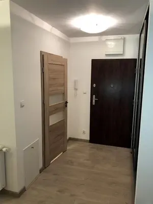a hallway with a door and a wooden door at Wielicka Apartment in Kraków