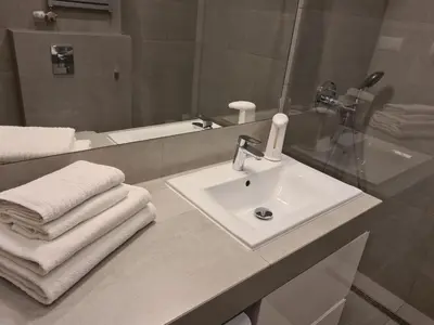a white bathroom with a sink and a mirror at Wielicka Apartment in Kraków
