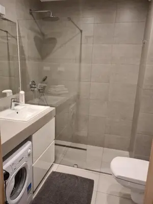 a bathroom with a sink and a washing machine at Wielicka Apartment in Kraków