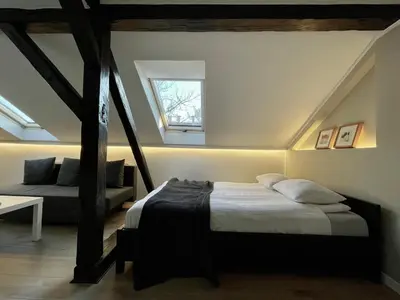 a bedroom with a bed and a couch and a window at Apartamenty Delecta in Kraków