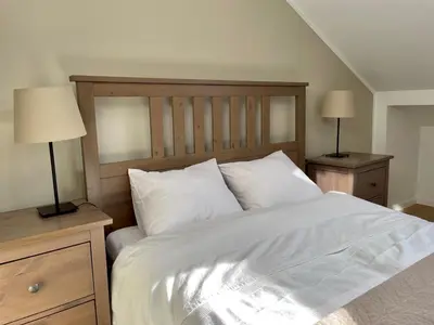 a bedroom with a large white bed with two lamps at Apartamenty Delecta in Kraków