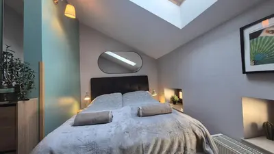 a bedroom with a large bed with a ceiling at Guesthouse Prusa 7 in Oświęcim