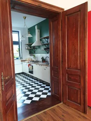 a kitchen with a black and white checkered floor at Guesthouse Prusa 7 in Oświęcim