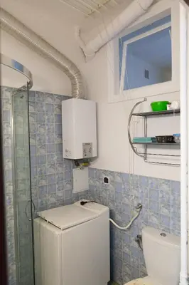 a small bathroom with a toilet and a refrigerator at Charming apt Old Town & Jewish District, quiet neighborhood in Kraków