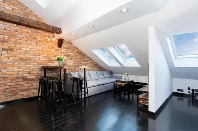 a living room with a couch and a brick wall at Apartments Starowislna Kazimierz Cracow by Noclegi Renters in Kraków