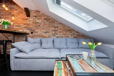 a living room with a couch and a brick wall at Apartments Starowislna Kazimierz Cracow by Noclegi Renters in Kraków