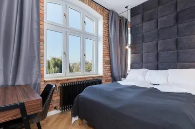 a bedroom with a bed and a desk and a window at Apartments Starowislna Kazimierz Cracow by Noclegi Renters in Kraków