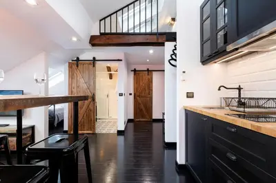 a kitchen with black cabinets and a counter with a sink at Apartments Starowislna Kazimierz Cracow by Noclegi Renters in Kraków