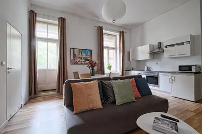 a living room with a couch and a kitchen at Urban Nest Apartments Świętego Marka27 in Kraków
