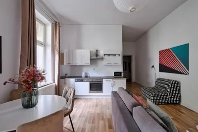 a kitchen and living room with a couch and a table at Urban Nest Apartments Świętego Marka27 in Kraków