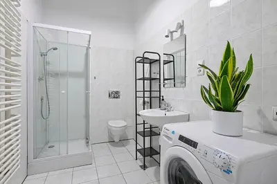 a washing machine in a bathroom with a toilet and a sink at Urban Nest Apartments Świętego Marka27 in Kraków