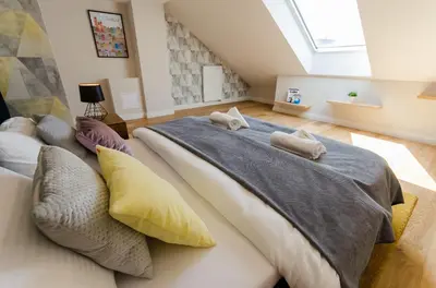 a bedroom with two beds with pillows at Kazimierz Penthouse with private terrace in Kraków