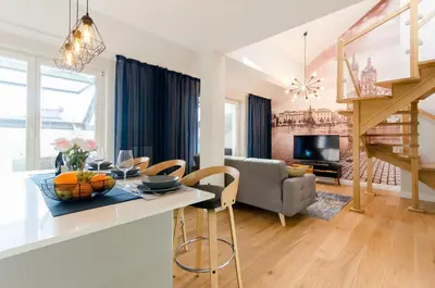 a kitchen and living room with a table and chairs at Kazimierz Penthouse with private terrace in Kraków