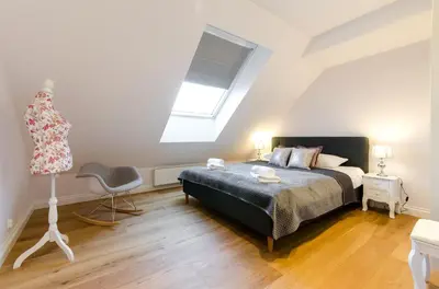 a bedroom with a bed and a window and a chair at Kazimierz Penthouse with private terrace in Kraków