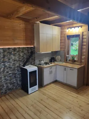 a kitchen with a stove and a microwave at Domek w Górach Prywatna Sauna i Balia in Klikuszowa