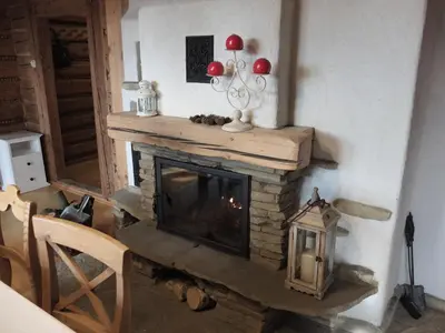 a fireplace in a living room with a fire place at Chata Mioduszyna w Beskidach - drewniany dom z widokiem na Babią Górę in Maków Podhalański