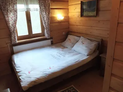a bed in a log cabin with a window at Chata Mioduszyna w Beskidach - drewniany dom z widokiem na Babią Górę in Maków Podhalański