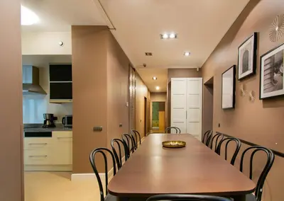 a dining room with a wooden table and chairs at Collosal 6 bedroom apartment Słowackiego avenue in Kraków