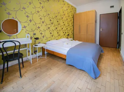 a bedroom with a bed and a desk and a mirror at Collosal 6 bedroom apartment Słowackiego avenue in Kraków