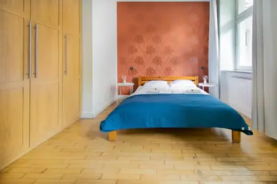 a bedroom with a large bed with a blue blanket at Collosal 6 bedroom apartment Słowackiego avenue in Kraków