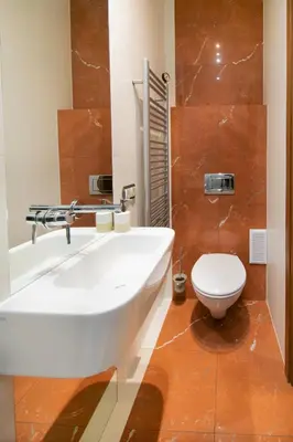 a bathroom with a white sink and a toilet at Collosal 6 bedroom apartment Słowackiego avenue in Kraków