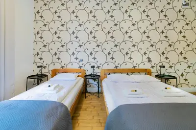 two beds in a room with a wallpaper at Collosal 6 bedroom apartment Słowackiego avenue in Kraków