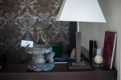 a statue of a girl sitting on a table next to a lamp at Hotel Oriza in Gdów