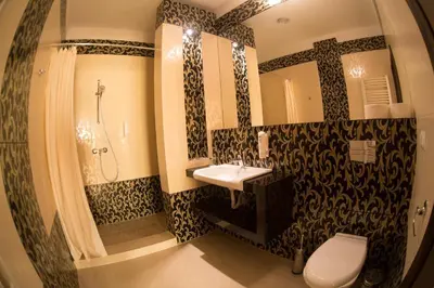 a bathroom with a sink and a shower and a toilet at Hotel Oriza in Gdów