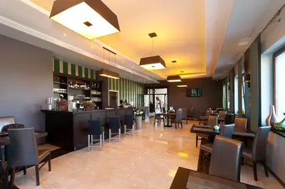 a restaurant with tables and chairs and a bar at Hotel Oriza in Gdów