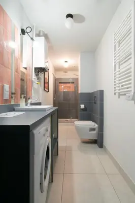 a bathroom with a washing machine and a toilet at Prestige location apartments Pijarska street in Kraków