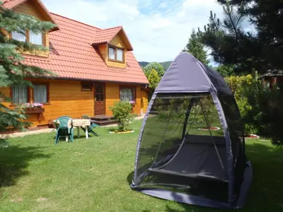 a table and chairs in a yard with a gazebo at Kraina Szczęśliwości in Zawoja