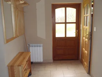 a window with a flower arrangement on a window sill with two stools at Kraina Szczęśliwości in Zawoja