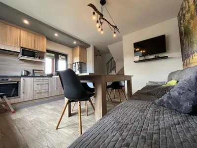 a kitchen and living room with a table and a couch at Przystanek Zapotocze in Słopnice