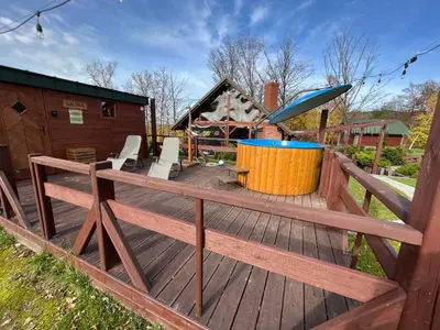 a wooden deck with a hot tub and a playground at Przystanek Zapotocze in Słopnice